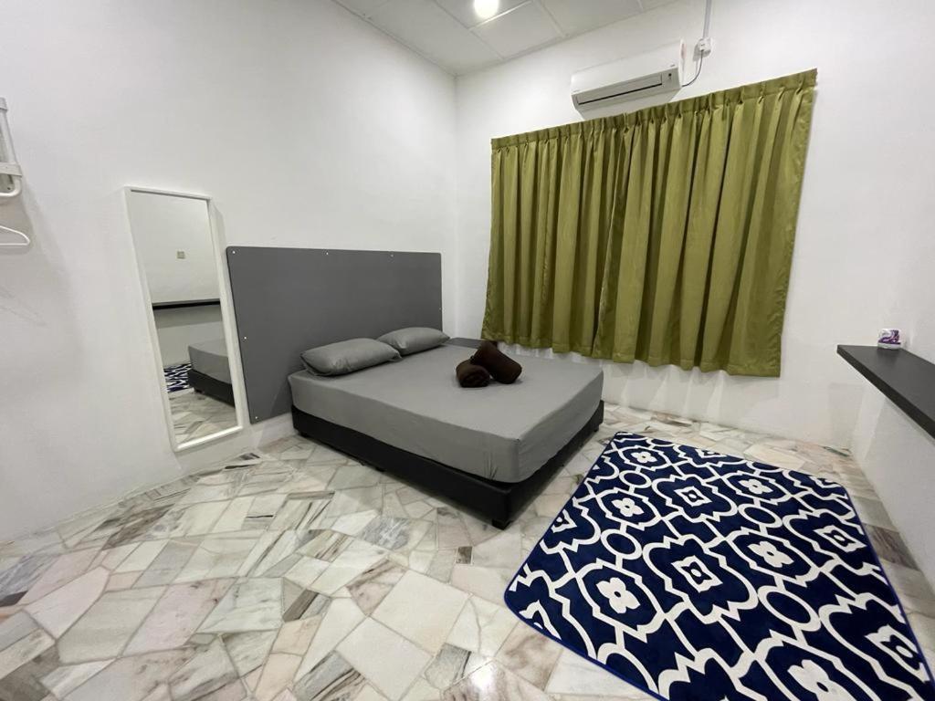 居銮My Delima Home for MusIim的一间卧室配有一张带绿帘和镜子的床