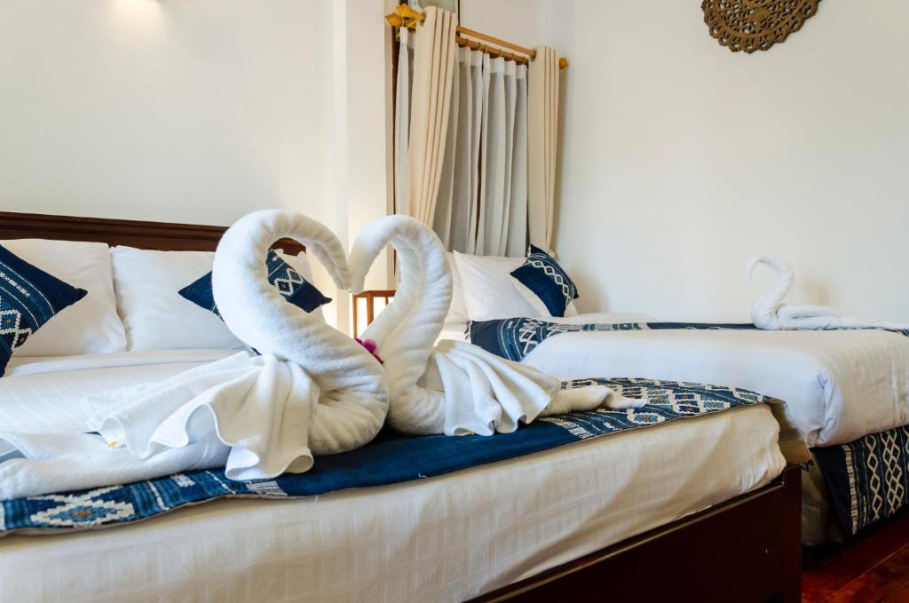 琅勃拉邦Villa Khili Namkhan的两个天鹅坐在床上