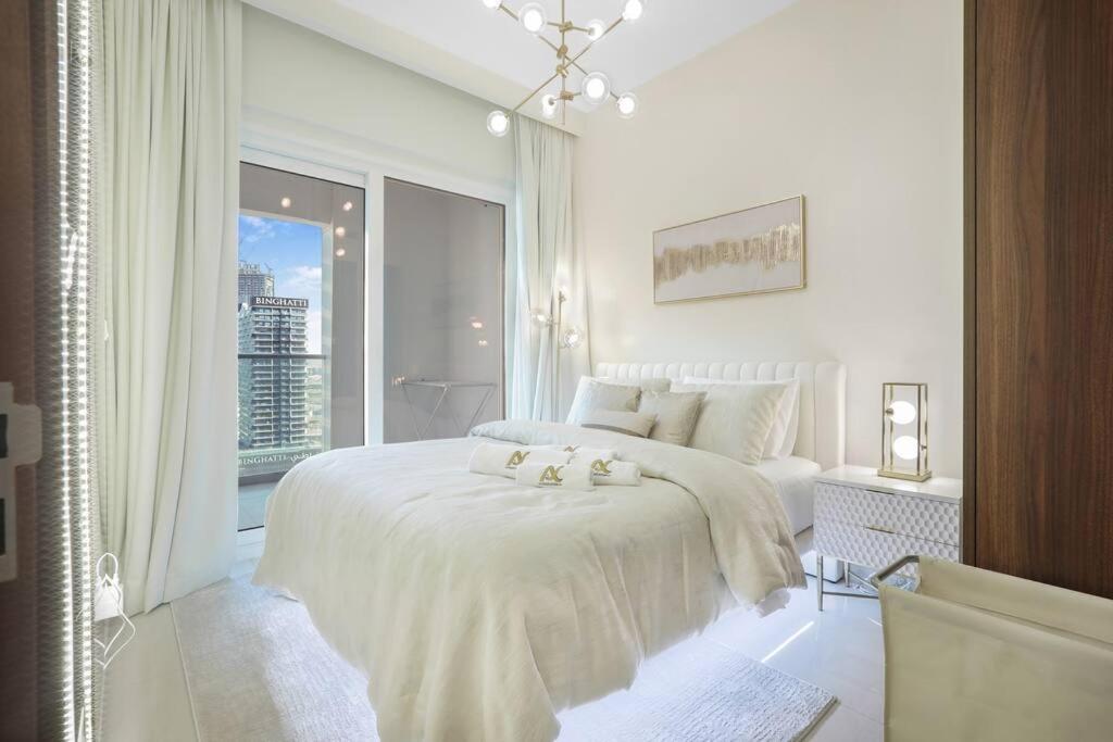 迪拜Luxe Den-1BR Cozy Treat By Canal side的白色的卧室设有床和大窗户