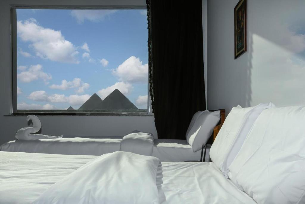 开罗NEW ASSER HOTEL PYRAMID的一间卧室设有一张床和一个大窗户