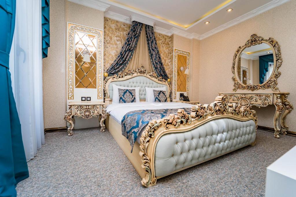 第比利斯Hotel Aqua Liberty的一间卧室配有一张金色床和两面镜子