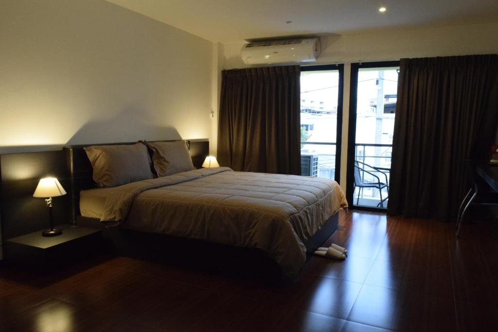 芭堤雅市中心疗养地酒吧及旅馆的酒店客房设有一张床和一个阳台。