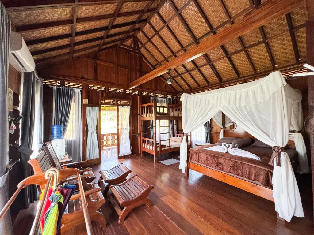 TimbanglawangOrangutan Orchard Bungalow的一间卧室,卧室内配有一张床和椅子