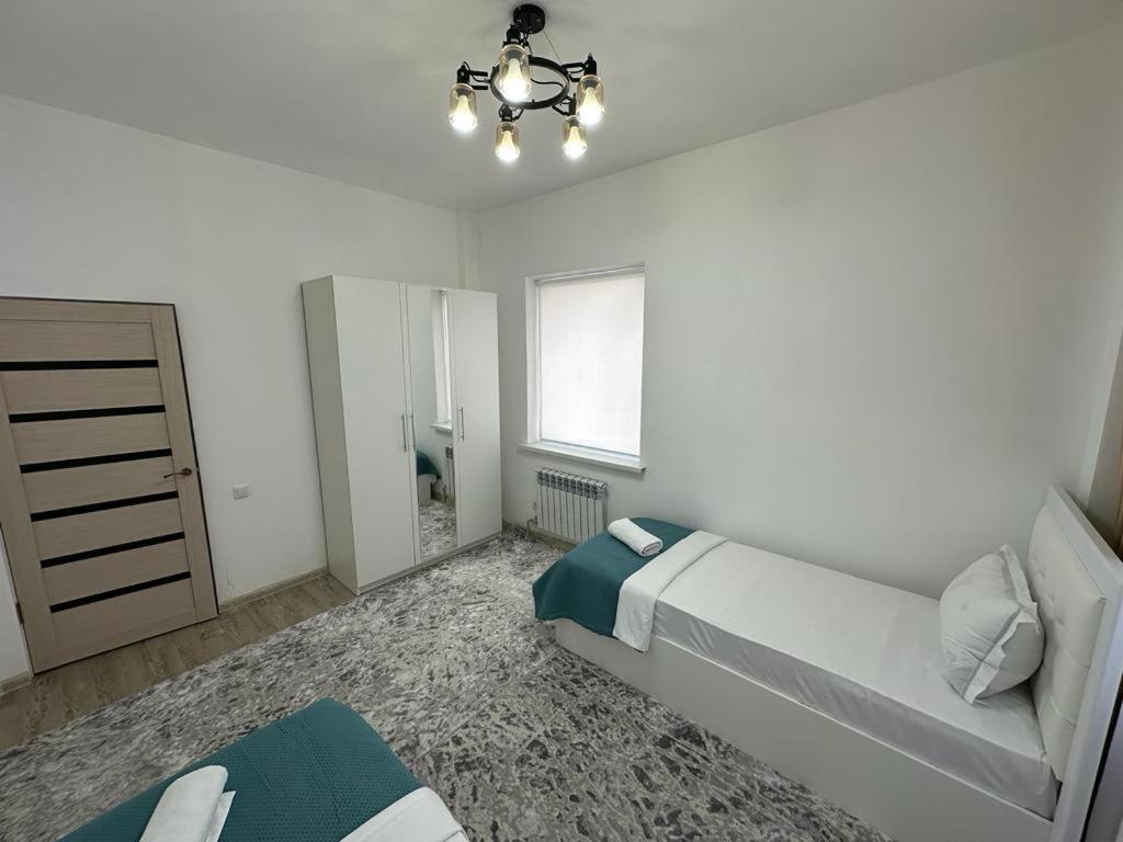 TürkistanКвартира的白色的卧室设有床和窗户