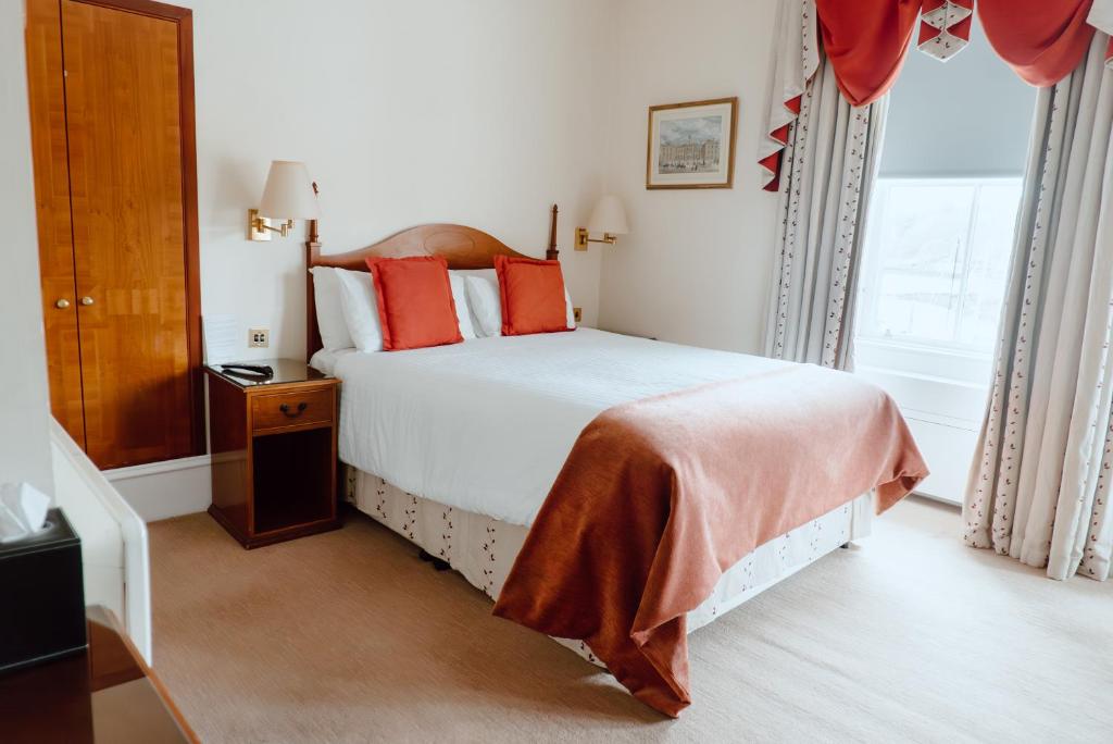 斯托诺韦皇家酒店的卧室配有带红色枕头的大型白色床