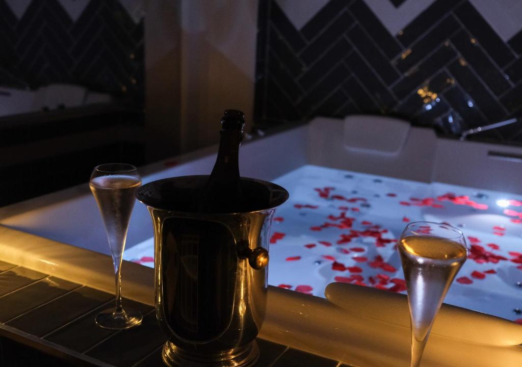 Les Essarts-le-RoiLe Cocon des Layes的浴缸内的一瓶香槟和两杯酒
