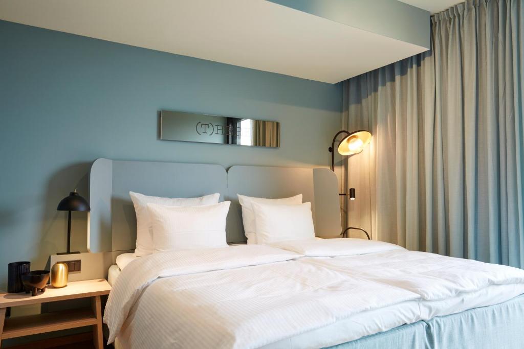 美因河畔法兰克福Scandic Frankfurt Hafenpark的一间卧室配有一张带白色床单的大床