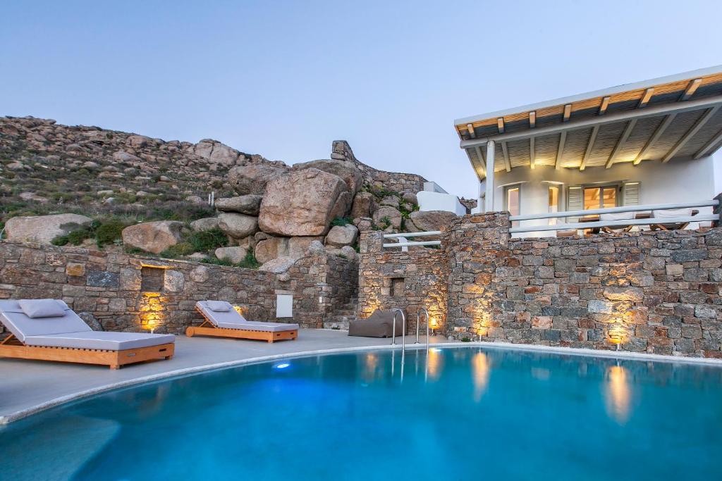 普拉迪斯亚罗斯Breathtaking 6 Bed in Platis Gialos的一座房子,设有游泳池,毗邻石墙