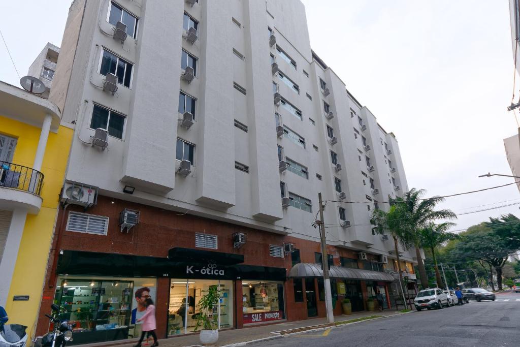 圣保罗Fênix Hotel Bom Retiro的大街上一座高楼,有商店