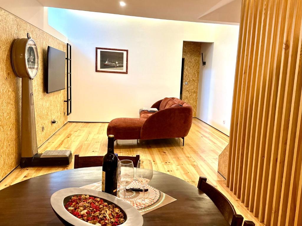里斯本A casa na Estrela的一张桌子,上面放着一瓶葡萄酒和比萨饼