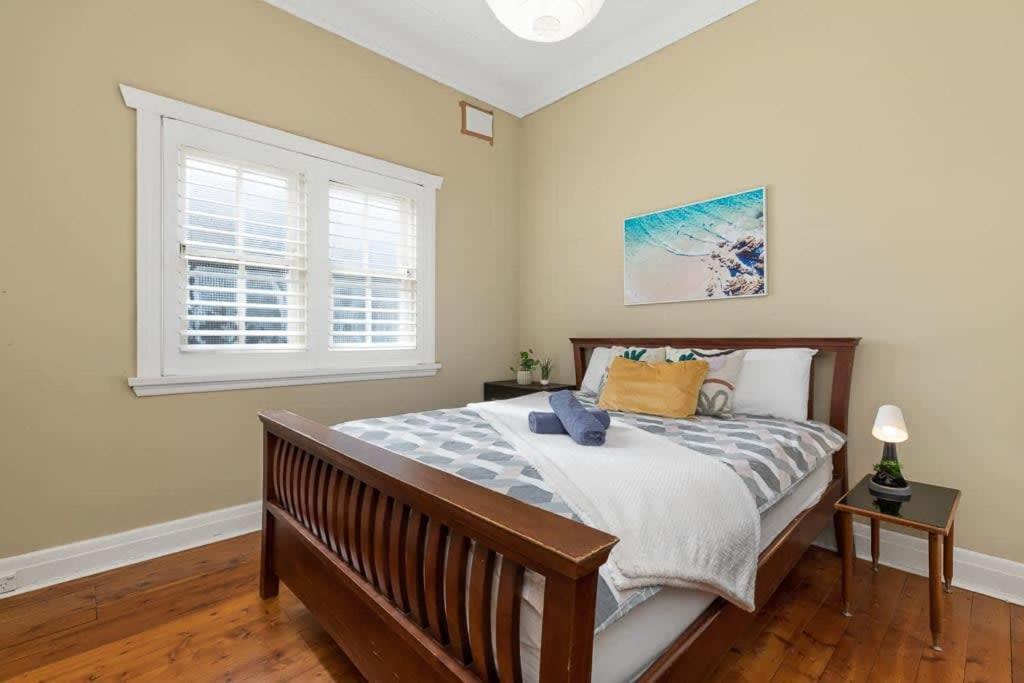 悉尼Cozy house in Kensington near UNSW & Light railway的一间卧室设有一张大床和一个窗户。