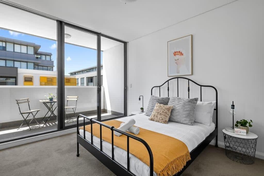 悉尼NEW 3BR Apt in Kingsgrove Sleeps 7的一间卧室设有一张床和一个大窗户