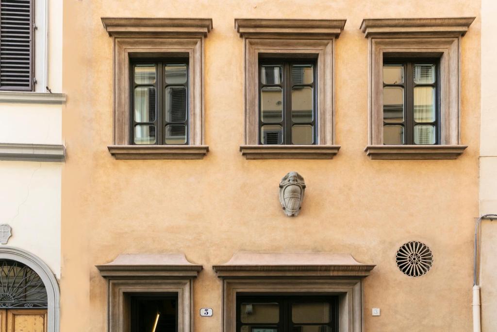 佛罗伦萨Numa Florence Goldoni的一座带窗户和面具的建筑