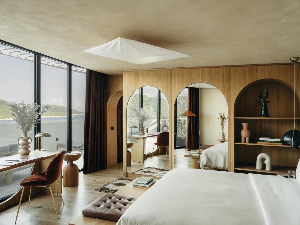 赫尔采格诺维Mamula Island的一间卧室配有一张大床和一张桌子及椅子