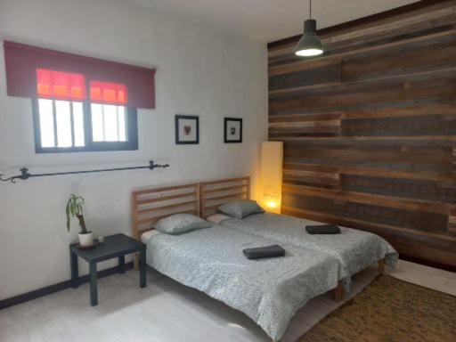 SooSunset house的一间卧室设有一张床和木墙