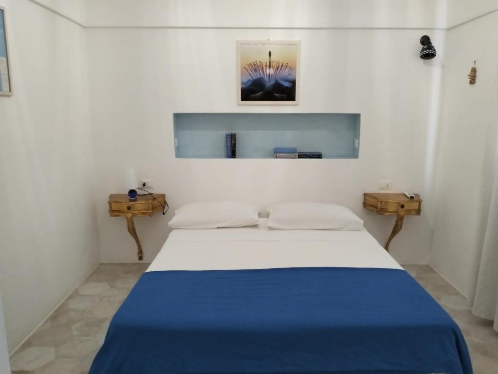 潘泰莱里亚Dammusielenas的白色客房,配有一张带蓝色毯子的床