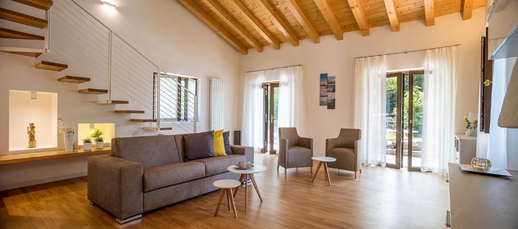 西斯蒂亚纳Residence Mare Azzurro Sistiana的客厅配有沙发和两把椅子