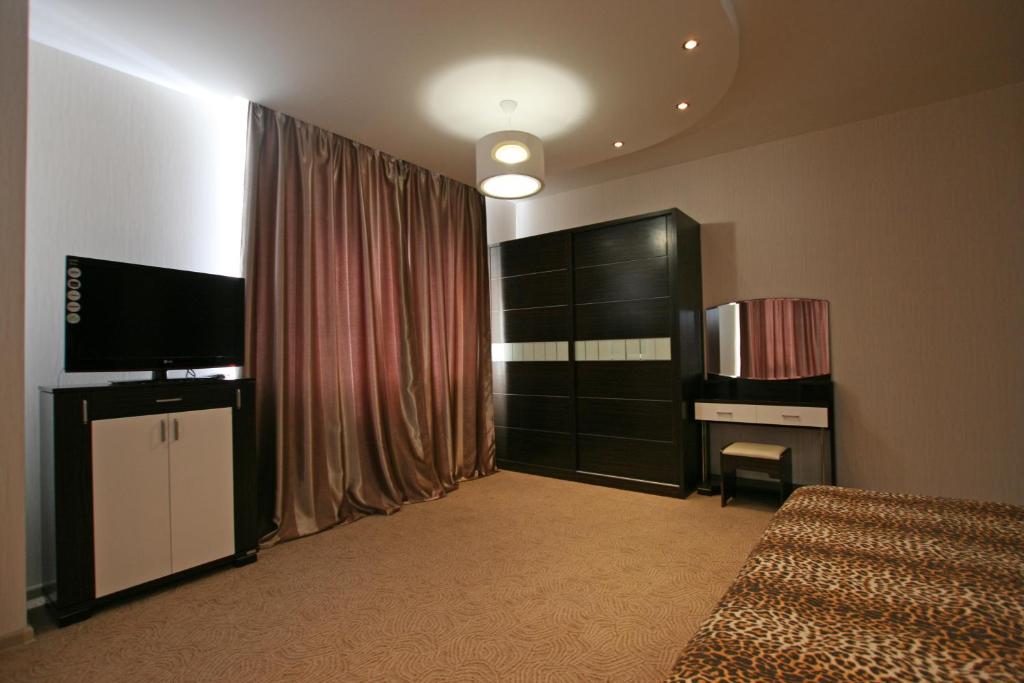 敖德萨Mini hotel in Observatorniy的一间卧室配有一张床、一台电视和一台电视机