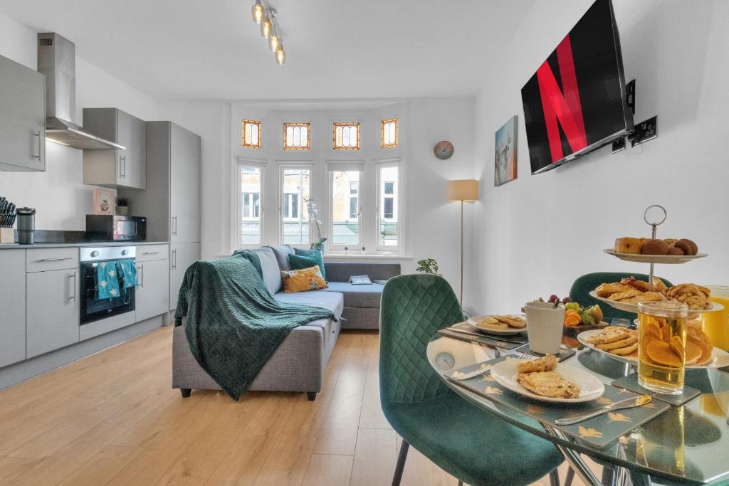 伦敦homely - West London Apartments Putney的厨房以及带桌椅的起居室。