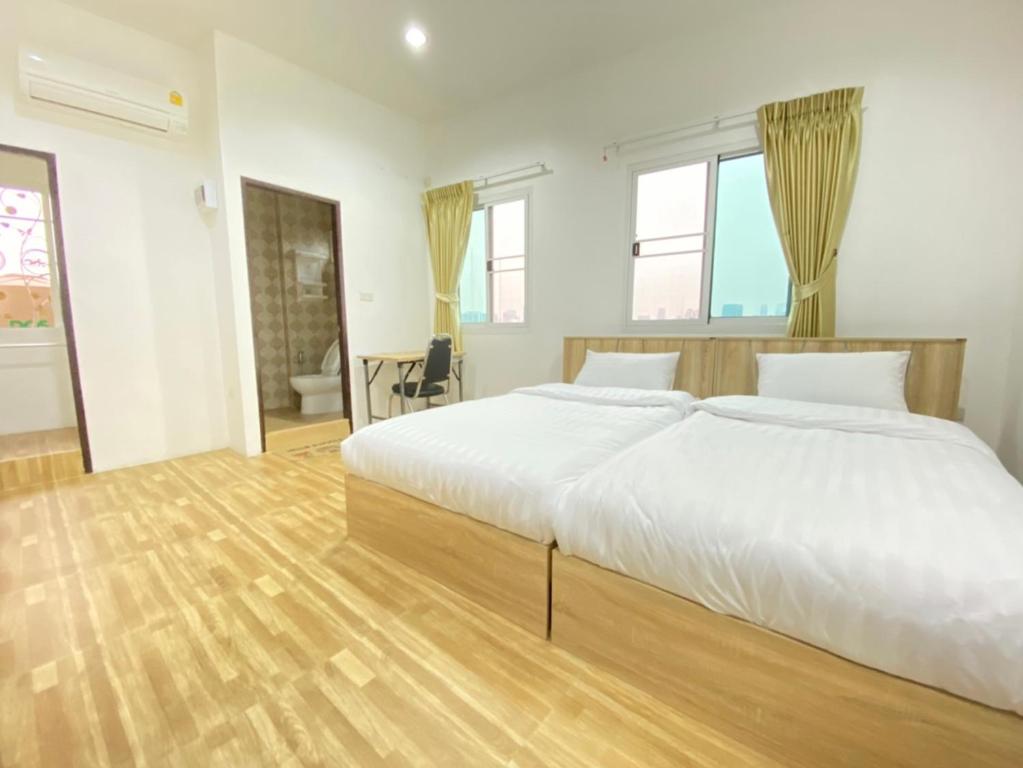 DusitWellness Mansion Hotel的卧室设有一张白色大床和木地板