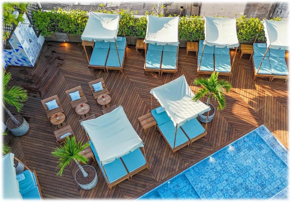 萨尔瓦多Fera Palace Hotel的享有带椅子和游泳池的天井的顶部景致