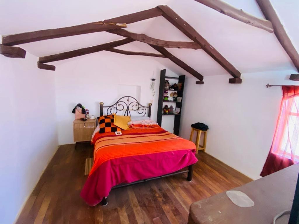 苏克雷MOSOJ LLAJTA的铺有木地板的客房内设有一间卧室和一张床。