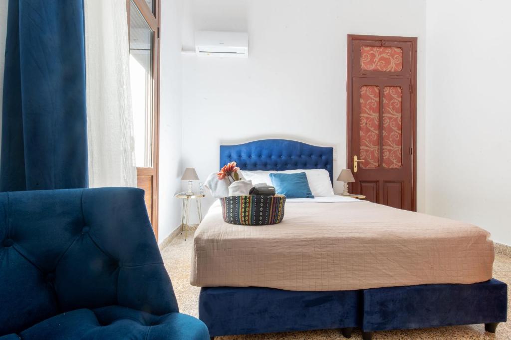 罗德镇mascot traditional guest house的一间卧室配有蓝色的床和蓝色椅子