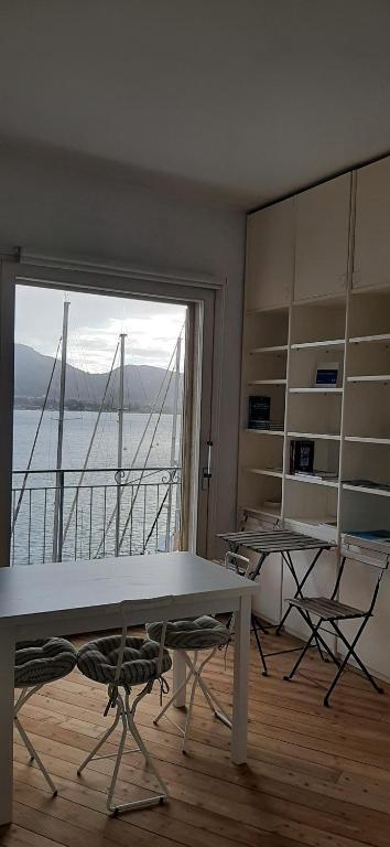 费拉约港Monolocale La Darsena的客房设有桌椅和大窗户。