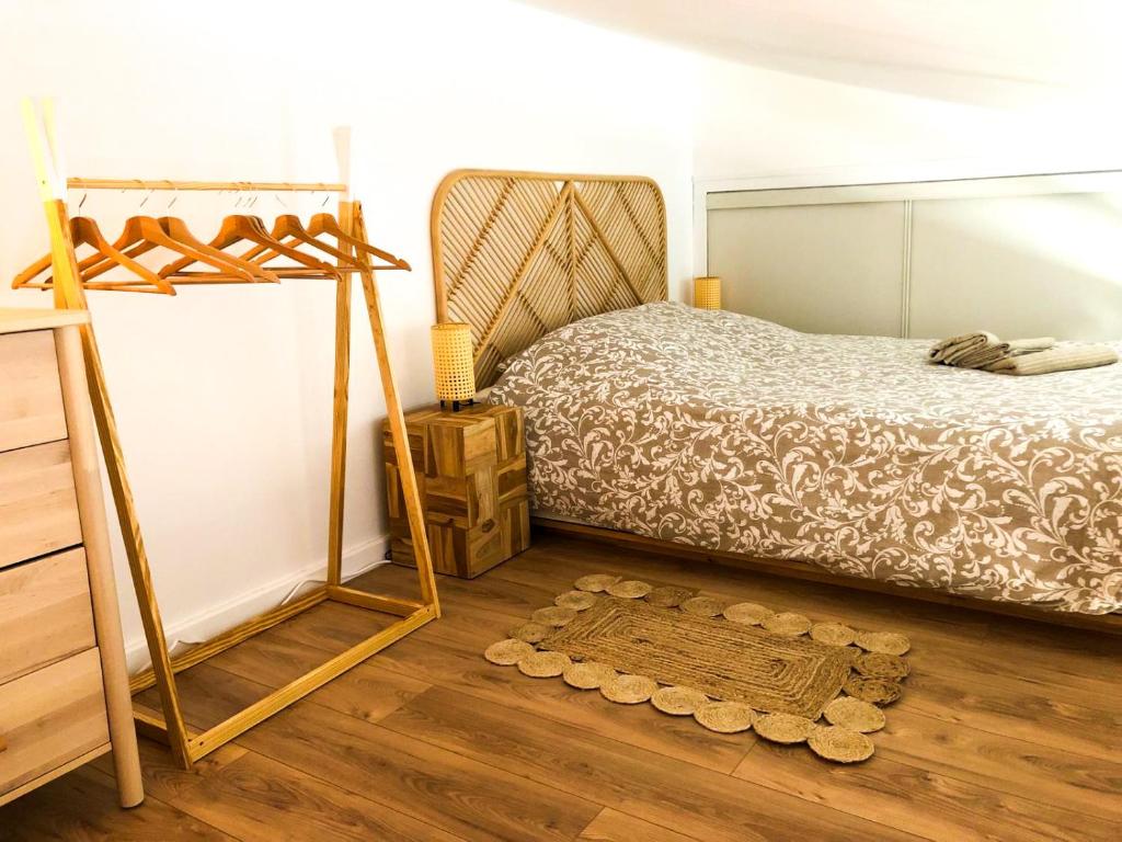 圣马丹德雷A 150m du port, Le Baia, tout à pied的一间卧室配有一张床,铺有木地板