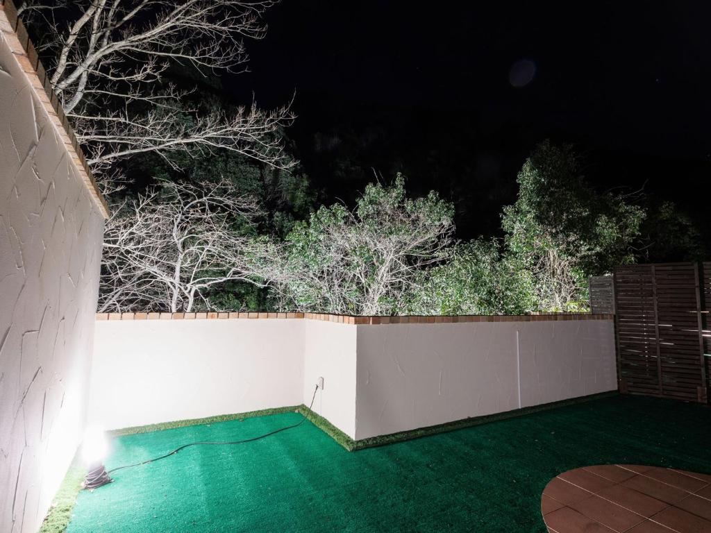 广岛Riverside Glamping Kamiseno - Vacation STAY 92757v的后院,晚上有白色的栅栏和树木