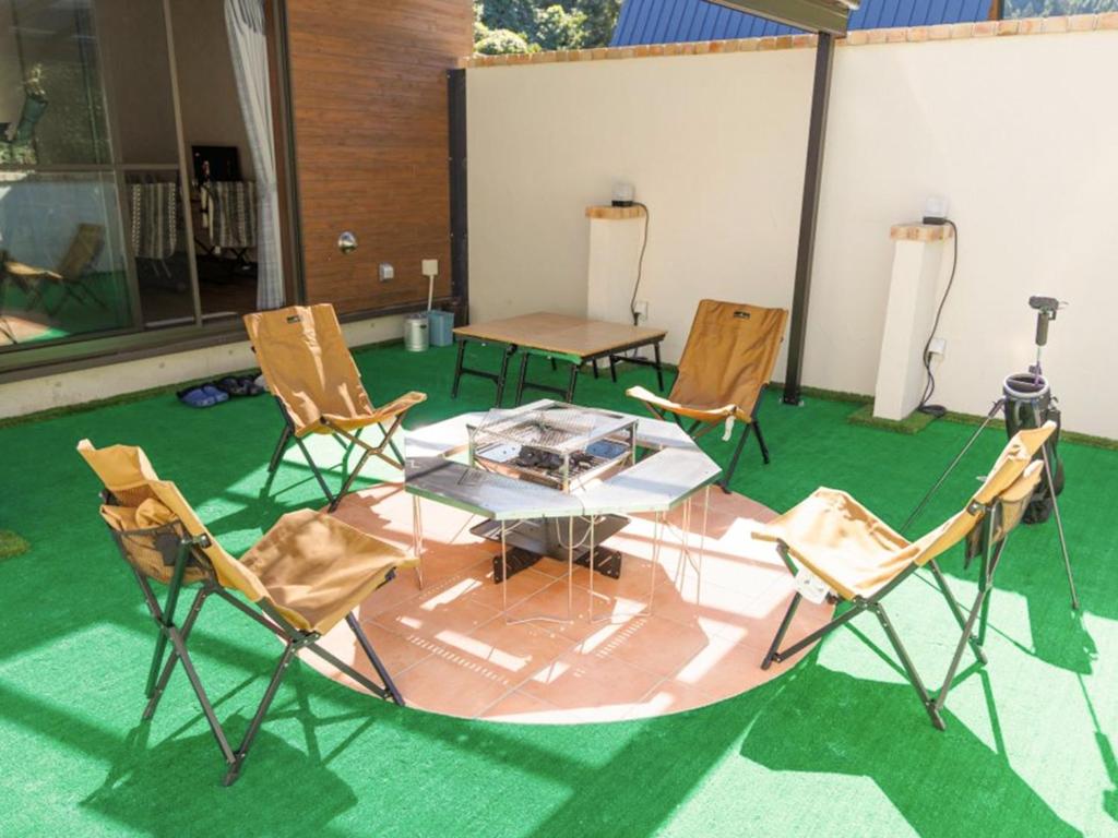 广岛Riverside Glamping Kamiseno - Vacation STAY 92763v的绿地庭院配有桌椅