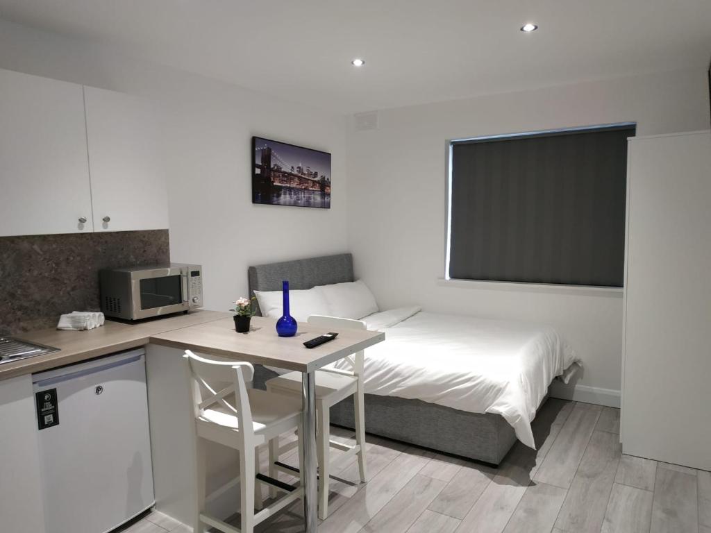 都柏林Oceanik的小房间设有床、桌子和厨房
