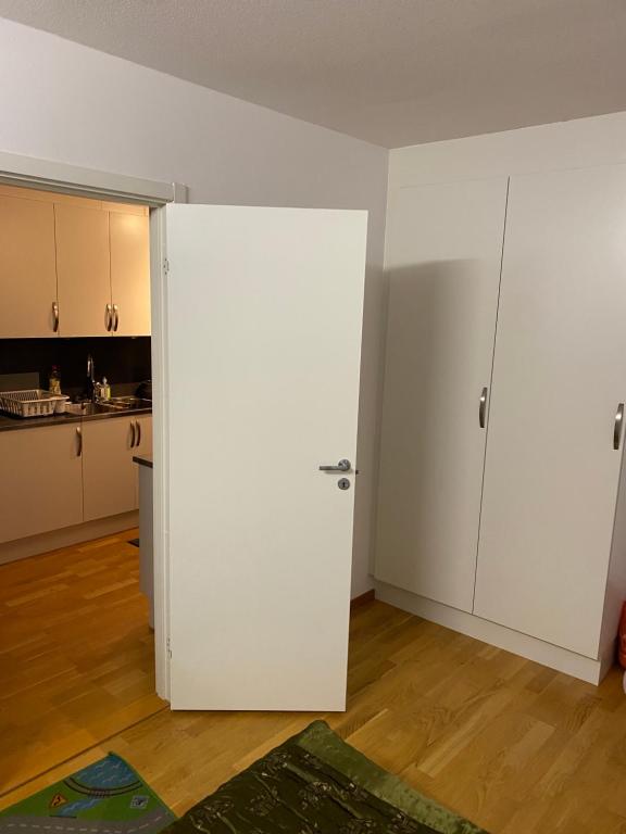 哥德堡Cozy room in a shared apartment close to nature的带厨房的房间里一扇白色的门