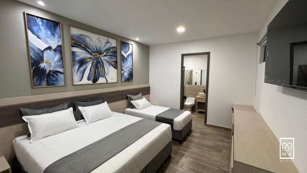 波帕扬M A Hotel的酒店客房设有两张床和电视。