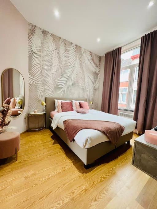 列日Charmant petit appartement.的一间卧室配有一张带两个粉红色枕头的床