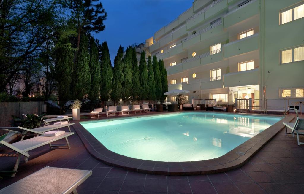 里米尼阿索托丽亚套房酒店的大楼前的大型游泳池