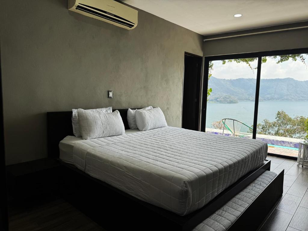 El CongoCardedeu Hotel Lago de Coatepeque的一间卧室配有一张床,享有水景