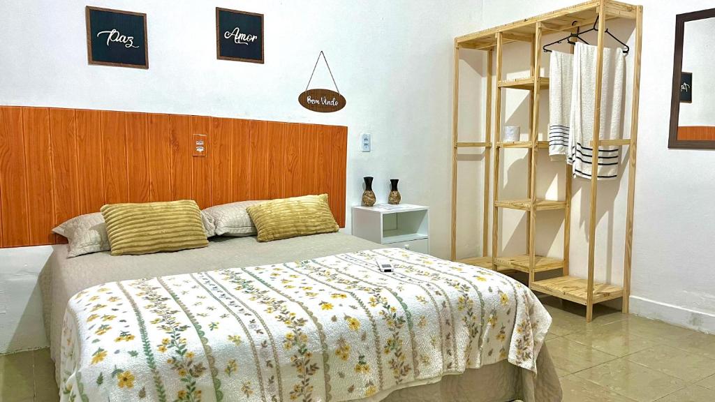 福塔莱萨Pousada Mar & Sol的一间卧室配有一张大床和木制床头板