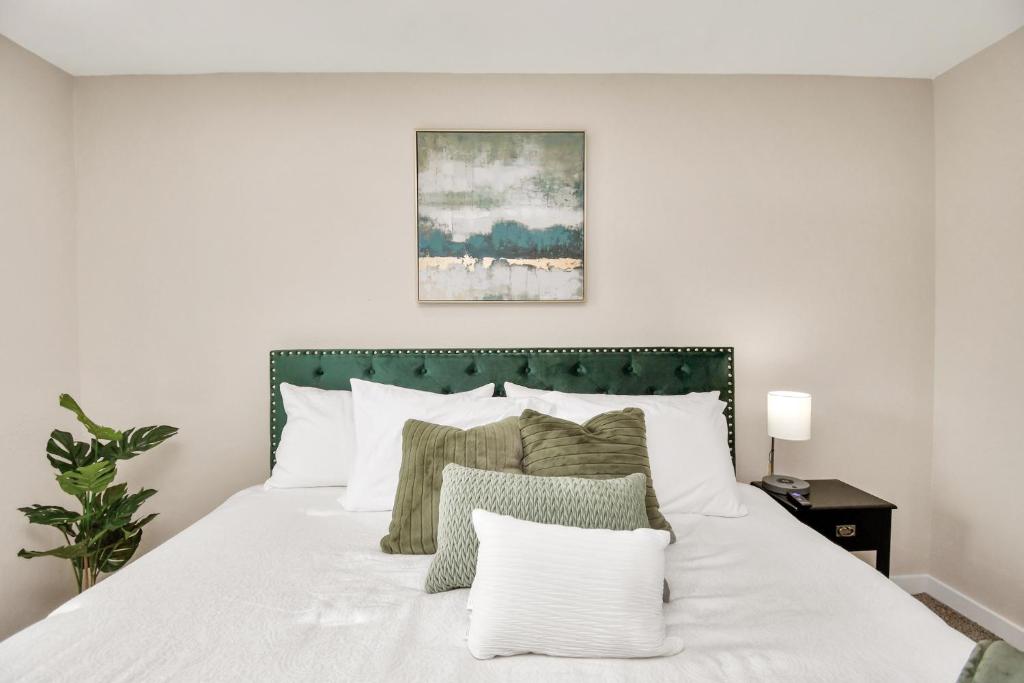 休斯顿The Dewberry的一间卧室配有一张白色床和绿色床头板