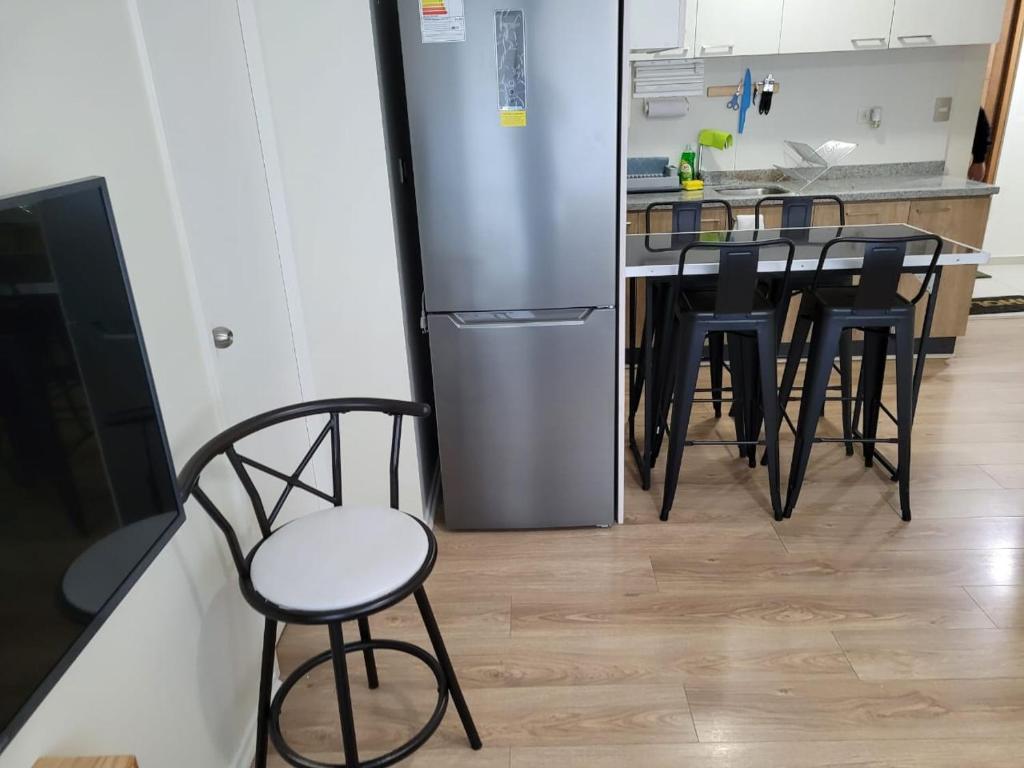 塔尔卡瓦诺Departamento Brisa del sol的厨房配有桌椅和冰箱。