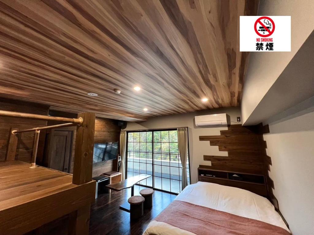 仙台Hotel 螢月ｰhozukiｰ Adult Only的一间卧室设有一张床和木制天花板