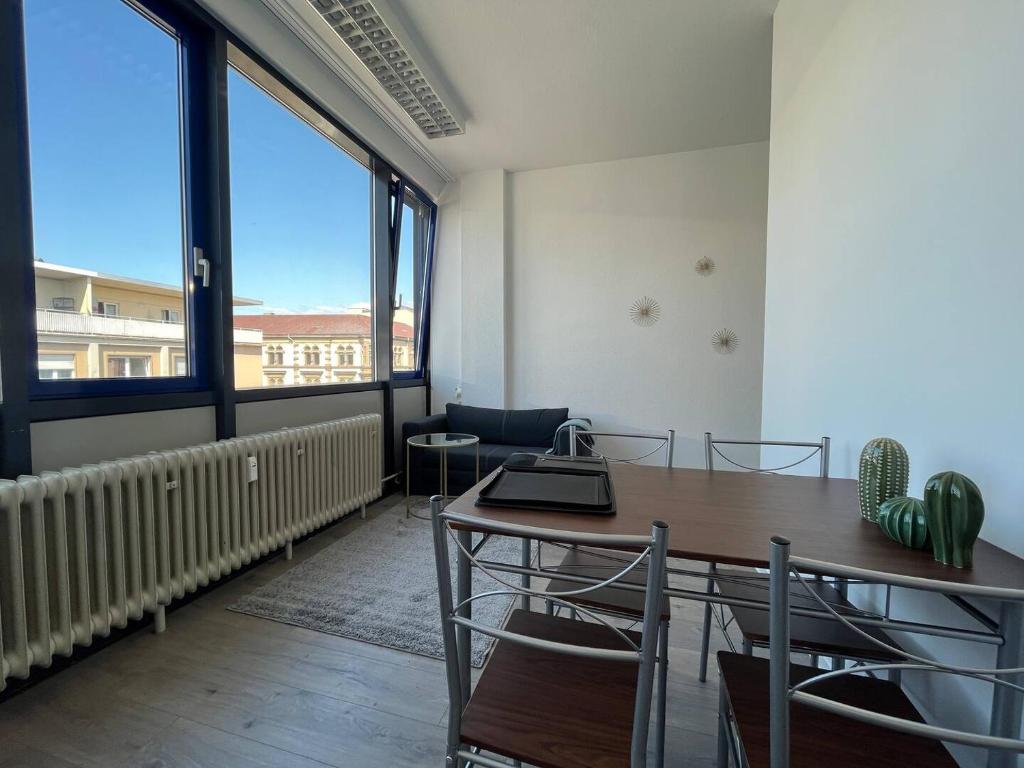 卡尔斯鲁厄Simplex Apartments Am Marktplatz的一个带桌椅和大窗户的办公室