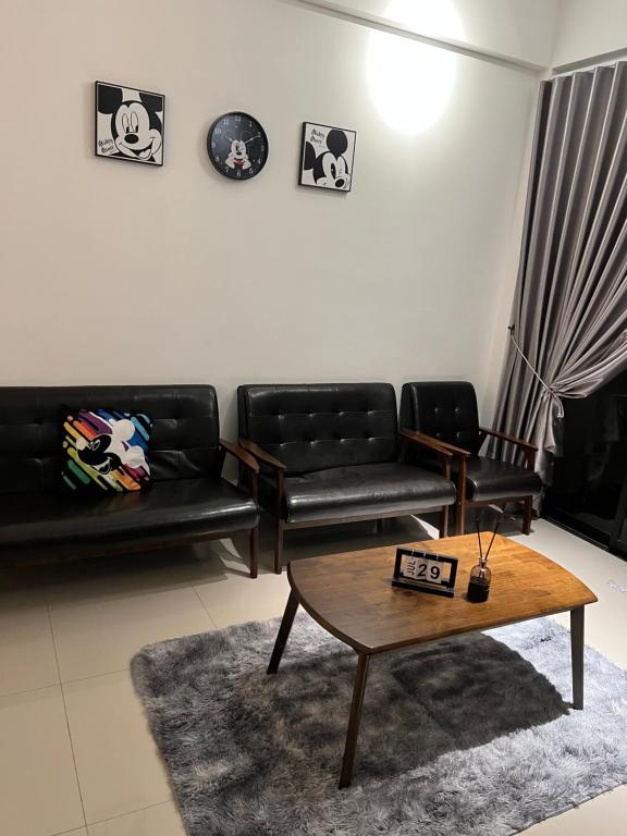怡保Ipoh cove 米奇黑白家庭的客厅配有黑色皮革家具和咖啡桌