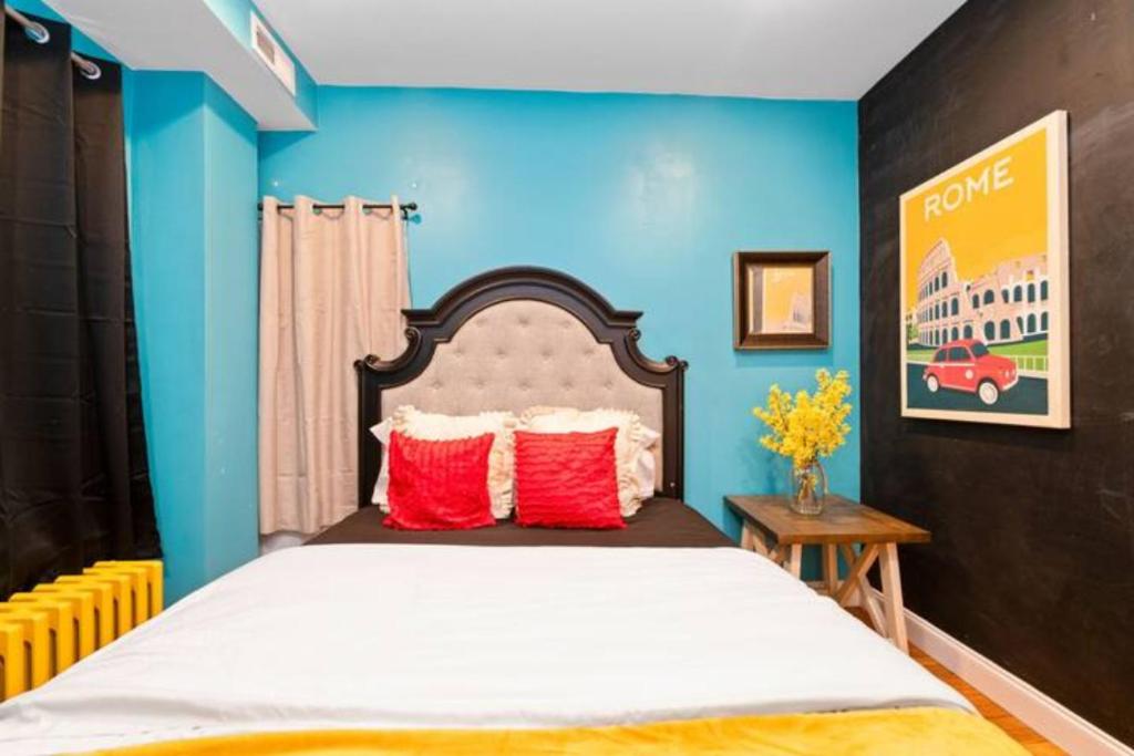巴尔的摩Charming Little Italy Baltimore Gem的一间卧室配有一张带蓝色墙壁和红色枕头的床