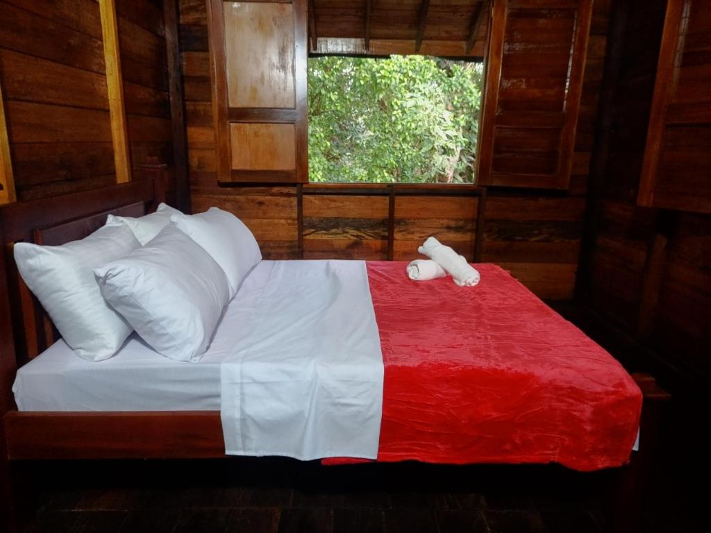 基布多Paraíso Verde Lodge的一间卧室配有一张带红白毯子的床