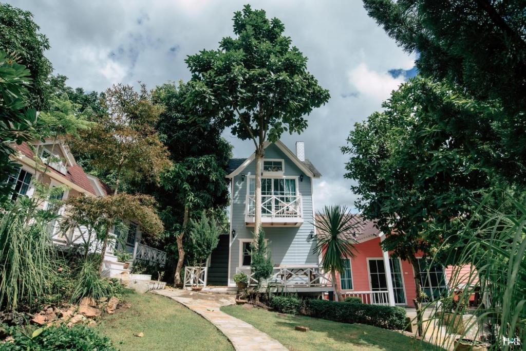 Tha KradanSuriyan Villa Erawan Kanchanaburi สุริยัน วิลล่า เอราวัณ กาญจนบุรี的院子里有树的白色房子