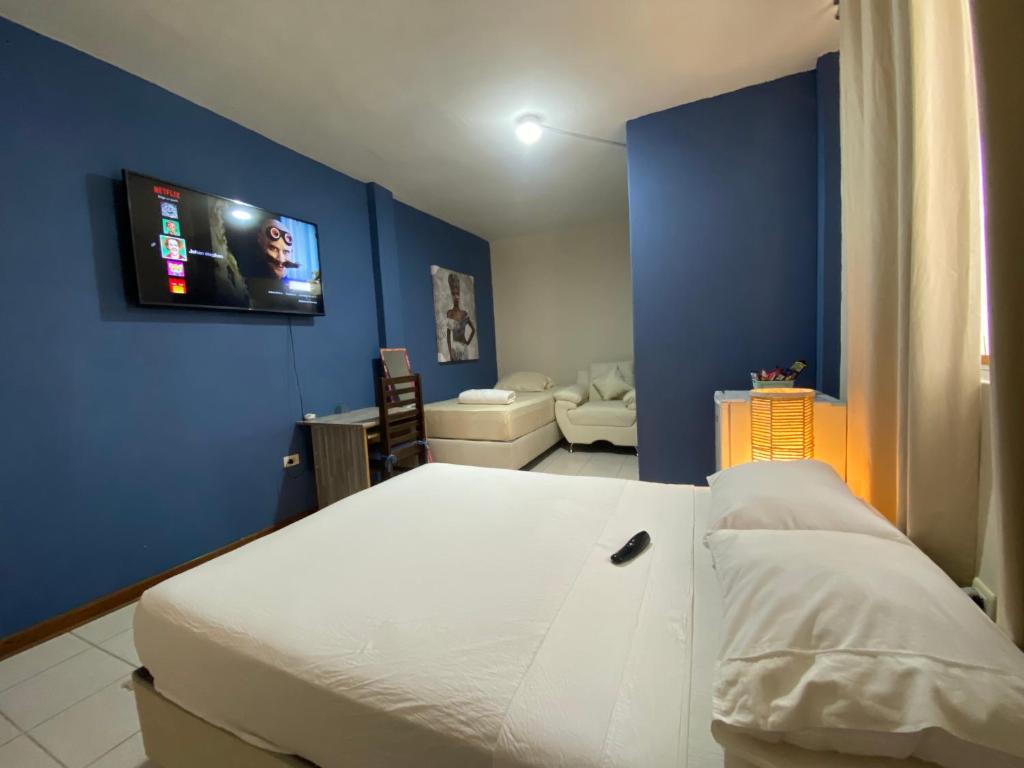 皮乌拉Casa Johans的卧室配有白色的床和蓝色的墙壁