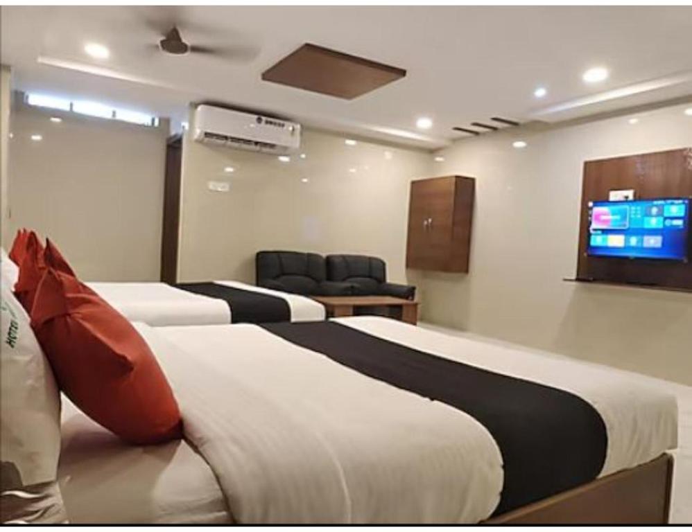 瓦朗加尔Hotel Grand Inn, Warangal的酒店客房设有两张床和一台平面电视。
