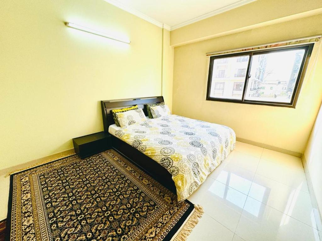 伊斯兰堡Zephyr Lodge的一间卧室设有床、窗户和地毯。