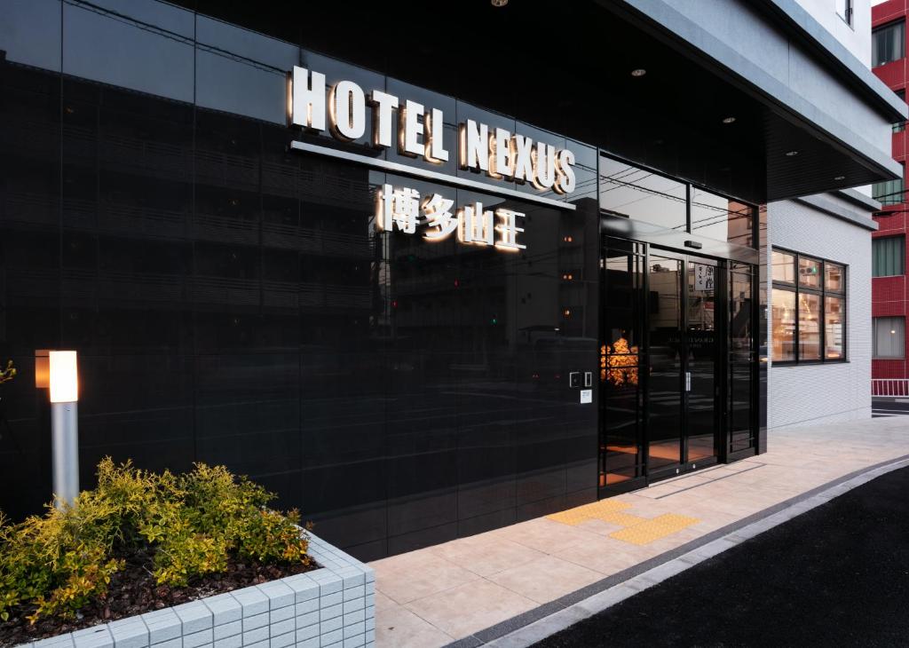 福冈HOTEL NEXUS Hakata Sanno的酒店大堂,大楼一侧有标志